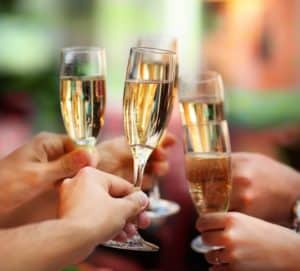 people toasting 4 glasses of champagne