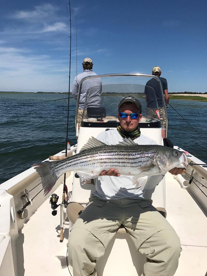 Fisherman shows large bass caught on fishing trip