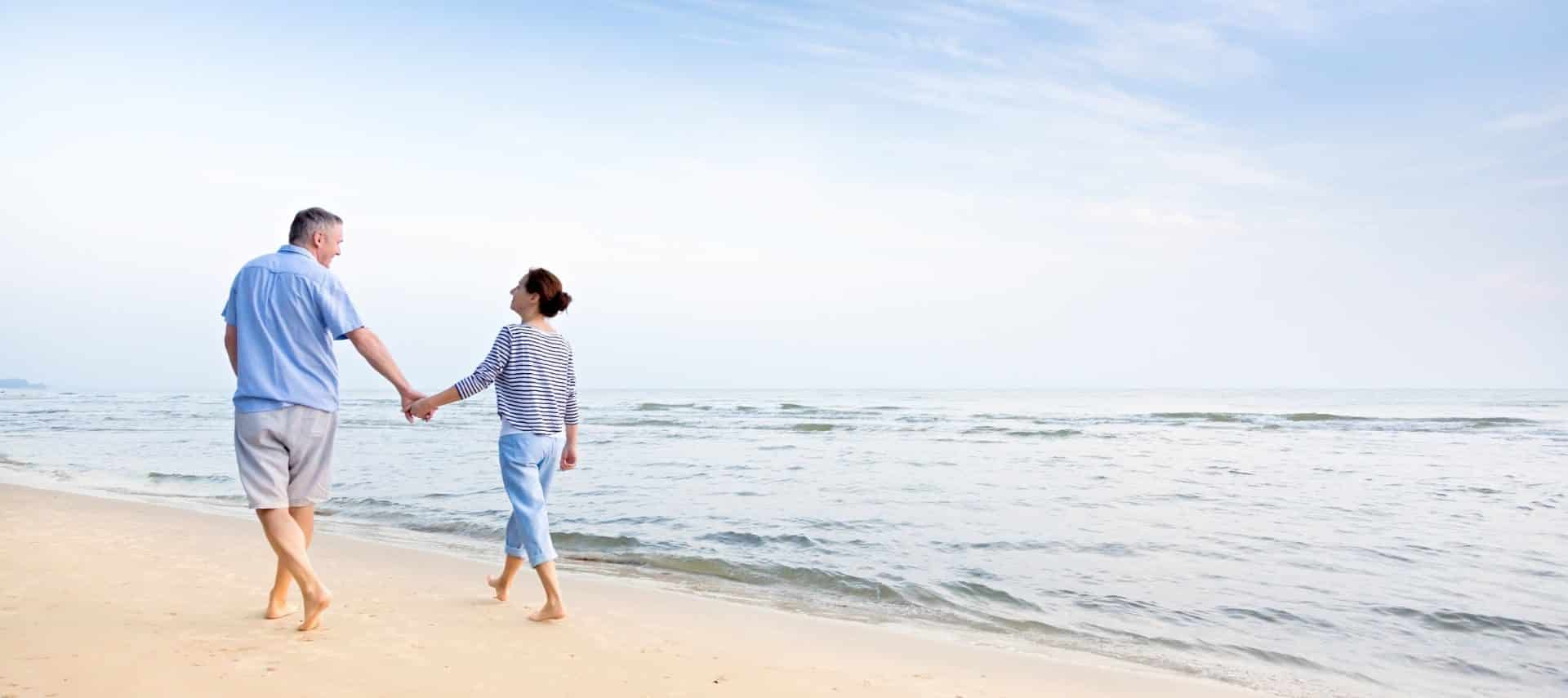 Couple walking hand in hand along the beach