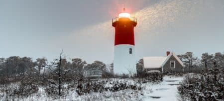 Nauseat Lighthouse during the winter on Cape Cod with sun rays shining down