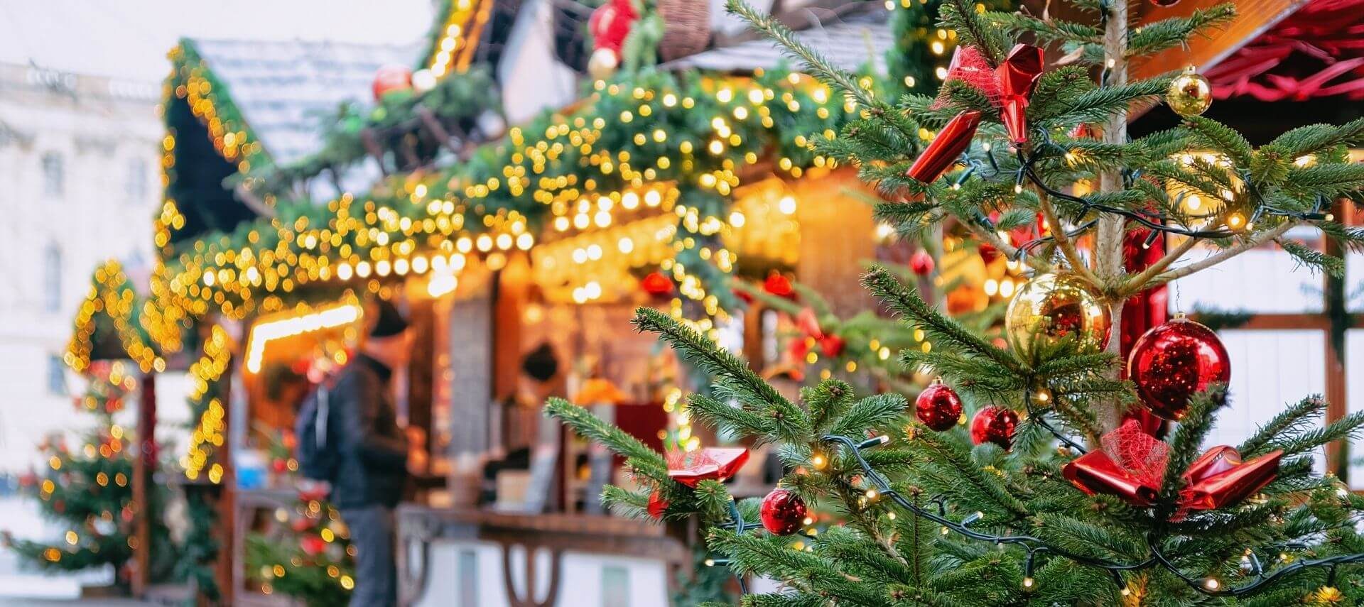 Open-air Christmas market decorated in Christmas finery and twinkling lights.