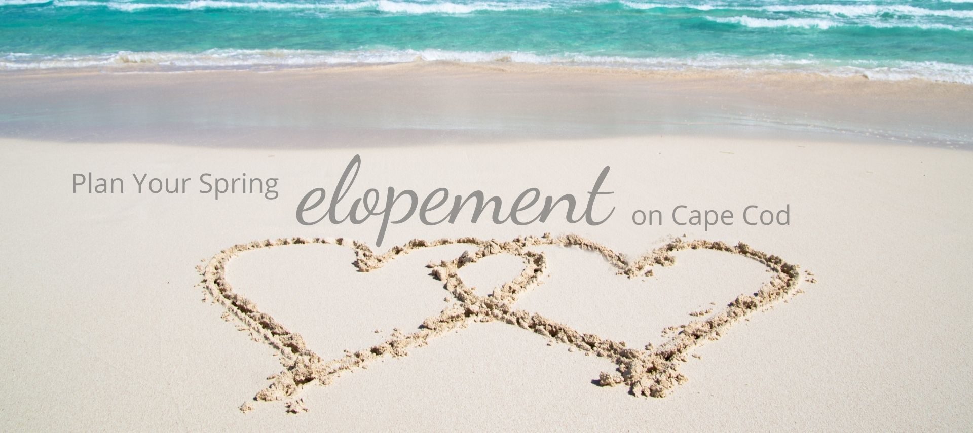 Two hearts drawn on a sandy beach with text “Plan Your Spring Elopement on Cape Cod”