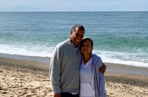 Bed and breakfast hosts smiling and hugging each other on the beach